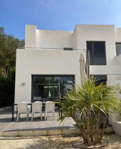 a patio with a table and chairs in front of a house at Villa Lux Mar in Cala Llena