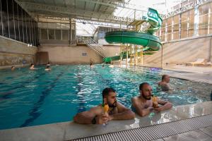 due uomini seduti in una piscina con delle bevande di Divaisib Termal Resort Hotel & Spa a Kozaklı