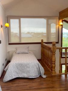 a bedroom with a bed and a large window at Casa Las Lengas in Puerto Natales
