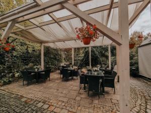 a dining area with tables and chairs under a pergola at Pokoje hotelowe Azyl in Kąty Wrocławskie