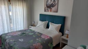 a bedroom with a bed with a blue headboard at Casa Luar in Odeceixe