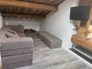 a living room with a couch and a flat screen tv at LA DOGANA . in Siena