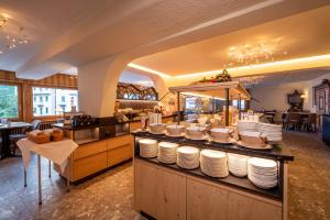 a restaurant with a counter with plates on it at Hotel Kreuz & Post Grindelwald in Grindelwald