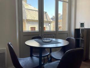 a table and chairs in a room with a window at Appartement Diamant 2 pers - L'Artdu'Net - in Sedan