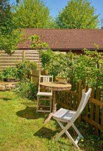 a table and chairs in a yard with a fence at Hofidyll in Felde +2 photos