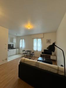 a living room with a couch and a table at Studio idéal Gare & Centre-Ville in Conflans-Sainte-Honorine