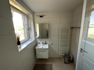 PalzemにあるHelfant Luxembourg Deluxe Triple Room 6の洗面台と鏡のある白いバスルーム +3枚の写真