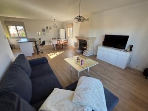 a living room with a couch and a table at Maison 6 pièces in Guéret