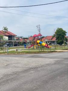 a playground with a slide on the side of a road at Cerah Homestay in Kampong Gong Kempas +4 photos