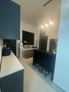 a kitchen with blue cabinets and a white counter top at Cerah Homestay in Kampong Gong Kempas