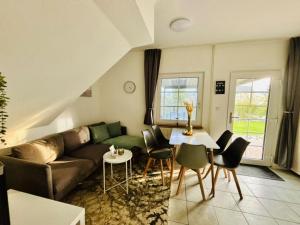 a living room with a couch and a table and chairs at Ferienhaus Usedom Familie Stopp Haus 21 in Lütow