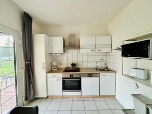 a small kitchen with white appliances and a window at Ferienhaus Usedom Familie Stopp Haus 21 in Lütow