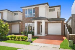 a large brick house with two garage doors at KozyGuru | Austral | Convenient 4 x Ensuite House in Austral