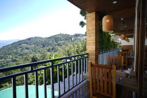 a balcony with a view of a pool and mountains at Mount Magnolia Boutique Hotel & Spa in Pelling