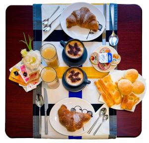 a table with plates of food and cups of orange juice at Hotel Boccascena in Genoa