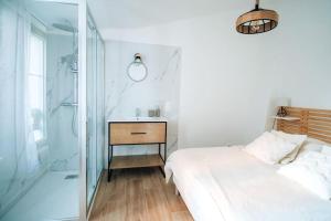 a bedroom with a bed and a glass shower at Le constantinou in Saint-Michel-lʼObservatoire