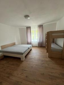 a bedroom with two bunk beds and a wooden floor at U maďarčika in Prituľany