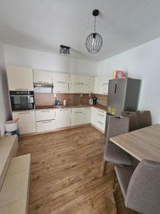 a kitchen with white cabinets and a wooden floor at U maďarčika in Prituľany
