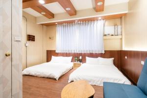 台南市にあるLazy days B&Bの窓のある小さな部屋にベッドが2つある