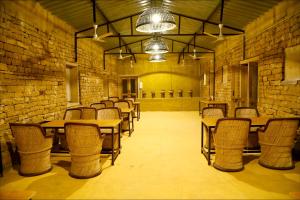 a room with tables and chairs and a brick wall at Vijay Bagh in Jaisalmer