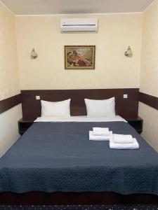 a bedroom with a blue bed with towels on it at Faraon Hotel in Ivano-Frankivsk +14 photos