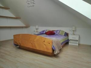 um quarto com uma cama de madeira num sótão em Panoramic View em Postojna