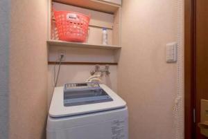 y baño pequeño con lavadora y secadora. en 大阪鶴橋, en Osaka