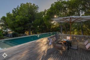 a patio with an umbrella and a table and chairs at Villa EL Azahar by Abahana Luxe in Altea la Vieja +24 photos