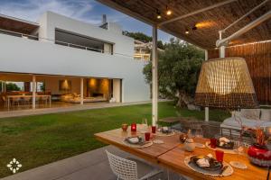 an outdoor dining area with a table and a house at Villa EL Azahar by Abahana Luxe in Altea la Vieja