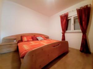 a bedroom with a large bed with orange sheets and a window at Charming Apartment Angela near Malinska in Sveti Anton