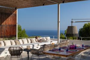 a woman sitting on a couch on a patio at Villa EL Azahar by Abahana Luxe in Altea la Vieja