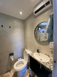 a bathroom with a toilet and a sink and a mirror at Lalau Casa de Playa in Chapadmalal +14 photos