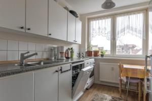 a kitchen with white cabinets and a sink and a table at Private Rooms in Hannover