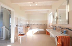 une salle de bain avec deux lavabos et une baignoire dans l'établissement Amazing Home In Dagebüll With Sauna, à Dagebüll