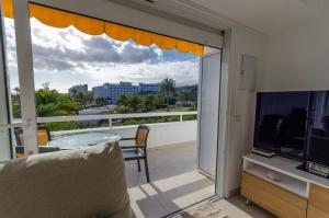 a balcony with a glass table and a television at Terraced 2 bedroom beach rental in Maspalomas