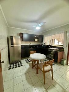 una cocina con una mesa y un refrigerador en 198 Vista Mar, en Praia Grande