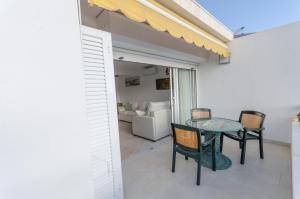 a dining room with a glass table and chairs at Terraced 2 bedroom beach rental in Maspalomas