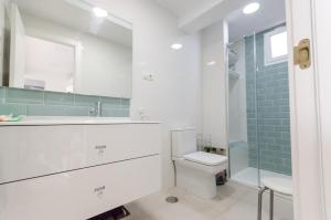 a bathroom with a toilet and a shower and a sink at Terraced 2 bedroom beach rental in Maspalomas +10 photos