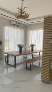 a table and bench in a room with a chandelier at White Garden in ‘Ayn al Fayḑah