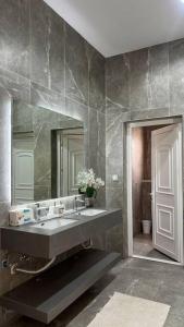 a bathroom with a sink and a mirror at White Garden in ‘Ayn al Fayḑah