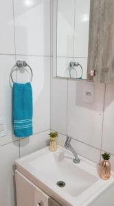 弗洛里亚诺波利斯Casa Florianópolis térreo Rio Vermelho的浴室水槽配有镜子和蓝毛巾