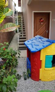 弗洛里亚诺波利斯Casa Florianópolis térreo Rio Vermelho的一座儿童玩具屋摆放在一栋房子前面。