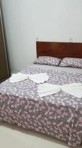 弗洛里亚诺波利斯Casa Florianópolis térreo Rio Vermelho的一间卧室，配有两张床、枕头和床罩