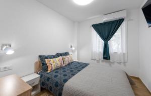 a small bedroom with a bed and a window at House Seaside Magnolias in Pirovac