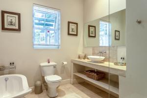 a bathroom with a toilet and a sink at Sandown Lodge in Cape Town +34 photos