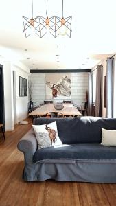 a living room with a blue couch and a table at Sublime Chalet 14 Pers Spa Extrieur in Cauterets