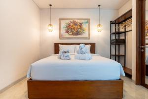 a bedroom with a bed with two teddy bears on it at Miles Coliving Bali, close to Seminyak and Canggu in Kerobokan