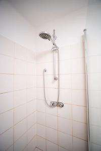 a shower in a white tiled bathroom at Monteurwohnung - Cityapartment in Worms