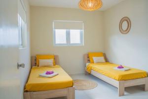 deux lits dans une chambre avec des draps jaunes dans l'établissement Toscana resort vakantie woning, à Willemstad