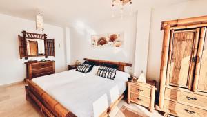 Un dormitorio con una cama y un armario de madera. en VillaCarajo La Herradura, en La Herradura